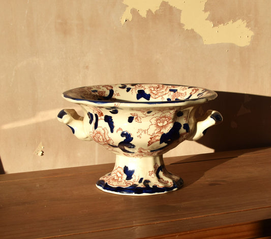 Brown and blue floral bowl with handles against a neutral background