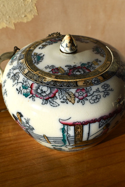 Decorative ceramic jar with floral patterns on a wooden surface