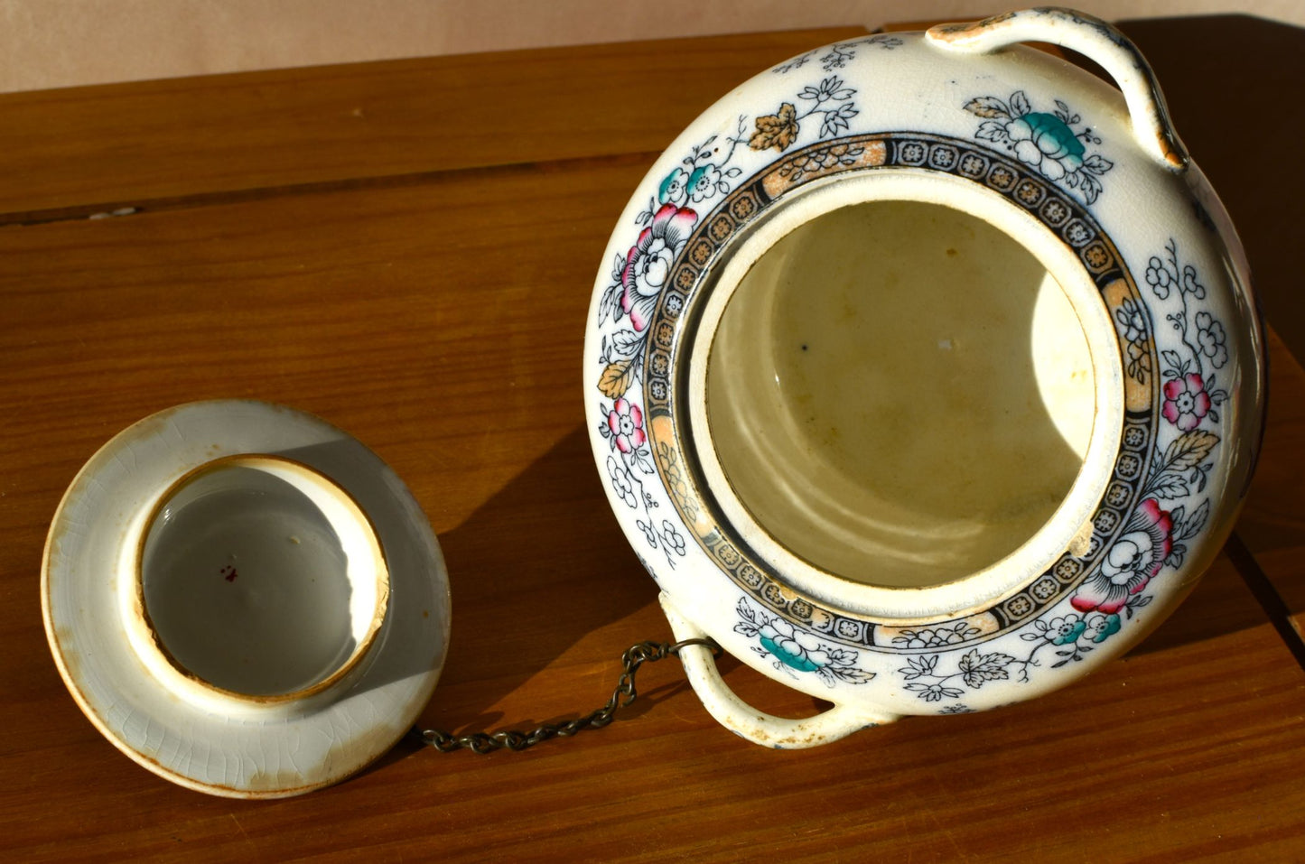 Decorative ceramic teapot with floral patterns on a wooden surface