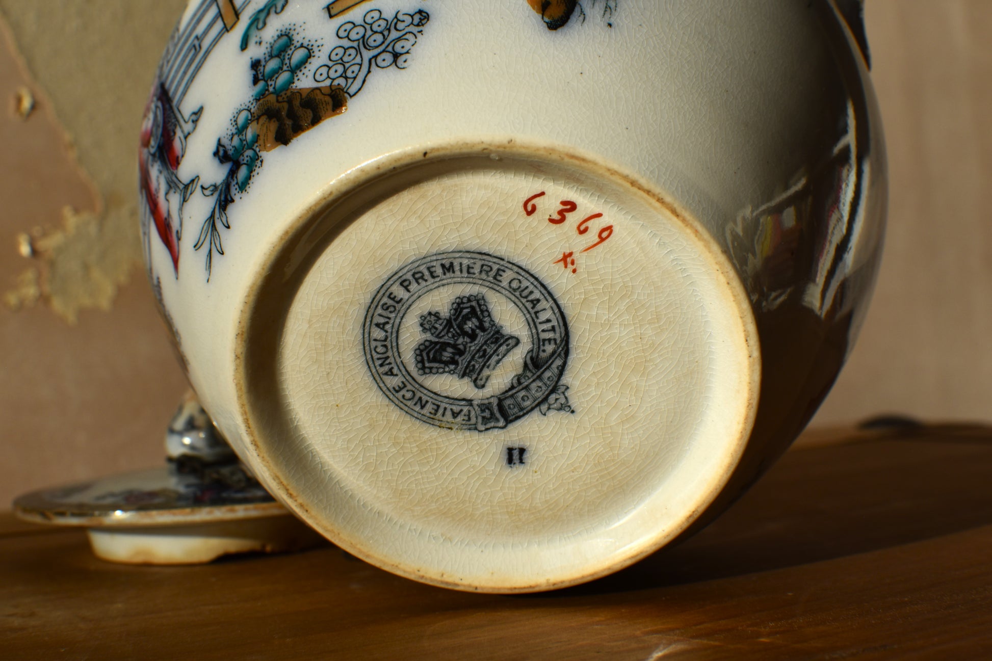 Close-up of a ceramic product with a visible brand logo and number on a wooden surface.