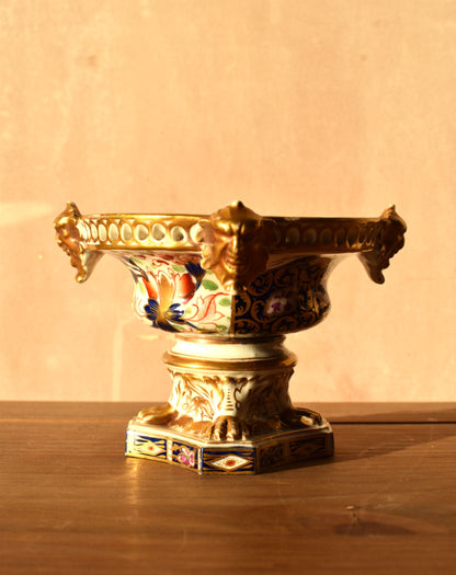 Decorative urn with intricate designs on a wooden surface