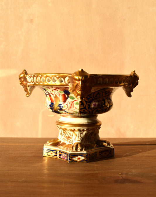 Decorative urn with intricate designs on a wooden surface