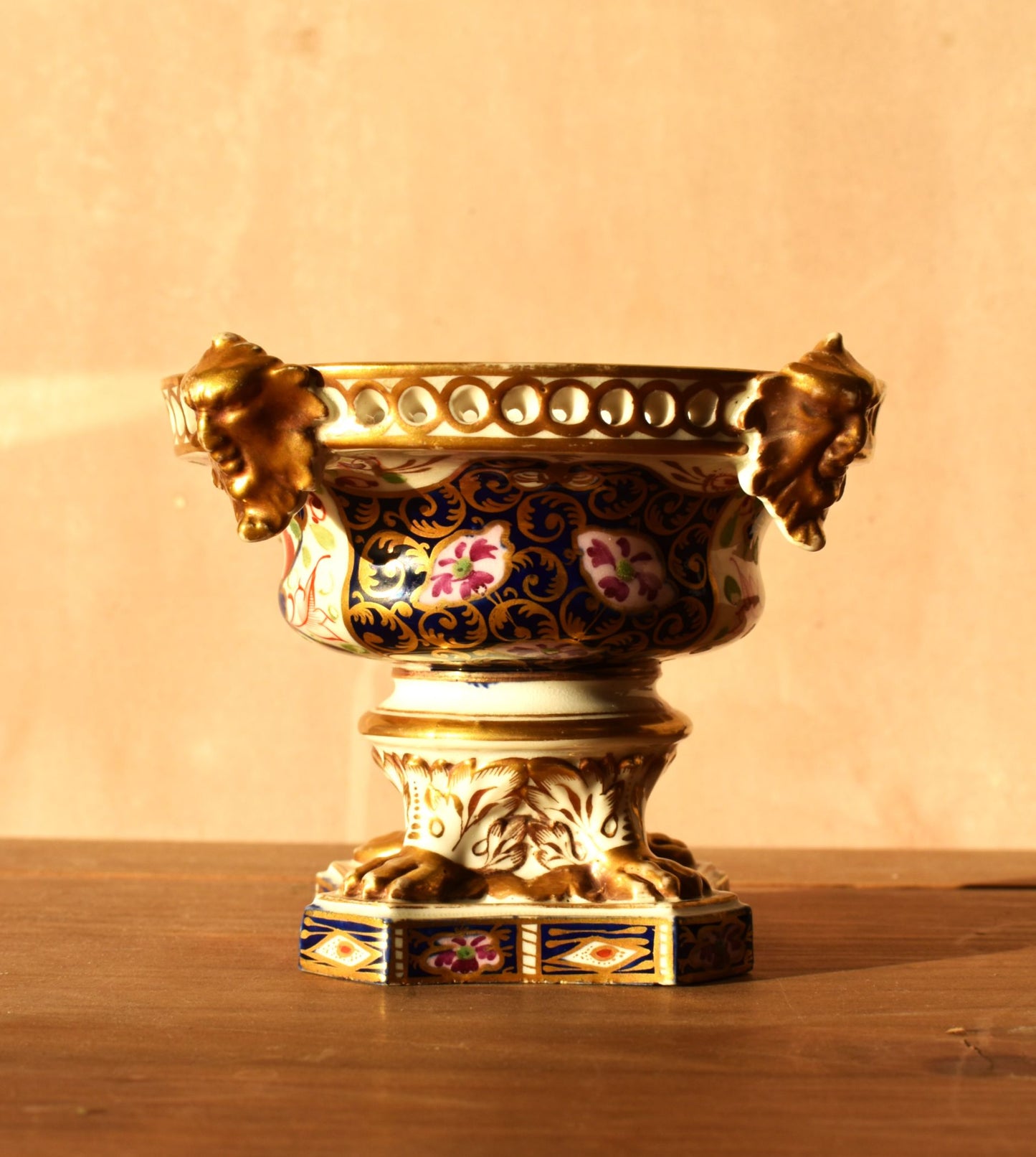 Decorative vase with floral patterns and gold accents on a wooden surface.