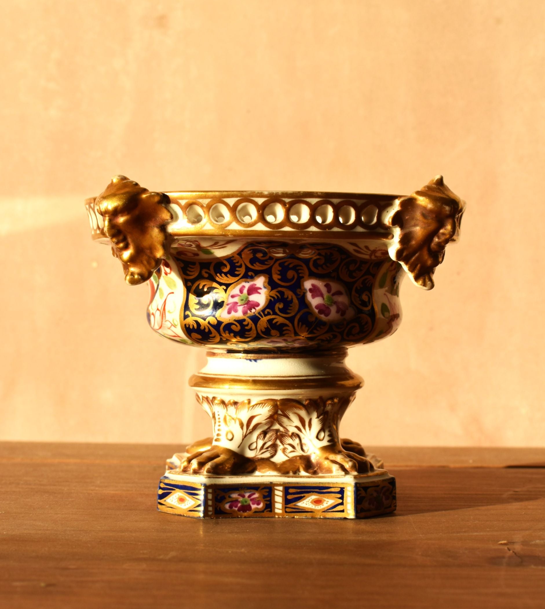 Decorative vase with floral patterns and gold accents on a wooden surface.